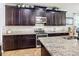 Well-appointed kitchen boasts granite counters, tiled backsplash, stainless appliances, and elegant dark wood cabinets at 9019 39Th Street Cir E, Parrish, FL 34219
