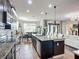 Modern kitchen featuring granite countertops, stainless steel appliances, a center island, and seamless flow to the dining area at 9019 39Th Street Cir E, Parrish, FL 34219