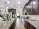 Open kitchen with large island, granite counters, stainless appliances, and dark cabinets; bright recessed lighting at 9019 39Th Street Cir E, Parrish, FL 34219