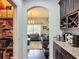 View from pantry of a kitchenette area with dark cabinets, wine storage, and open view of the inviting living room at 9019 39Th Street Cir E, Parrish, FL 34219