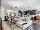 Open-concept living room with a white sectional sofa, dark hardwood floors, and a view of the gourmet kitchen at 9019 39Th Street Cir E, Parrish, FL 34219