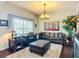 Cozy living room with plush leather furniture, a stylish chandelier, a large window, and hardwood floors at 9019 39Th Street Cir E, Parrish, FL 34219