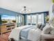 Stylish main bedroom with accent wall, wooden dresser, and a large TV with a tranquil beach scene at 9019 39Th Street Cir E, Parrish, FL 34219