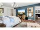 Bright main bedroom boasts an accent wall, stylish ceiling fan, and a large mirror reflecting the ensuite bathroom at 9019 39Th Street Cir E, Parrish, FL 34219