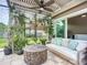 Landscaped covered patio with a comfortable daybed and decorative plants at 9019 39Th Street Cir E, Parrish, FL 34219