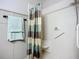 Tiled shower features a shower curtain and grab bars for accessibility at 9019 39Th Street Cir E, Parrish, FL 34219