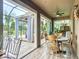 Bright sunroom featuring tile floors, large windows, and a dining table, with views of the backyard oasis at 9019 39Th Street Cir E, Parrish, FL 34219