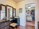 Elegant vanity with ornate mirrors and a stool, leading into a closet with custom shelving at 9019 39Th Street Cir E, Parrish, FL 34219