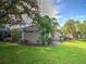 A serene backyard featuring a screened-in lanai, a lush lawn, and beautiful landscaping at 912 Barclay Ct, Venice, FL 34293