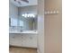 Neutral-toned bathroom features a double sink vanity, large mirror, and ample storage at 912 Barclay Ct, Venice, FL 34293