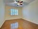 Empty bedroom with hardwood floors, ceiling fan, and plantation shutters for plenty of natural light at 912 Barclay Ct, Venice, FL 34293