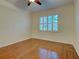 Well-lit bedroom featuring hardwood floors and window with plantation shutters at 912 Barclay Ct, Venice, FL 34293