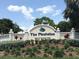 Well-manicured entrance to The Plantation Golf & Country Club under a blue, slightly cloudy sky at 912 Barclay Ct, Venice, FL 34293
