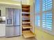 Spacious kitchen with stainless steel refrigerator and custom pull-out shelving for ample storage at 912 Barclay Ct, Venice, FL 34293