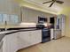 Bright kitchen with white cabinets, black countertops, stainless steel appliances, and tiled flooring at 912 Barclay Ct, Venice, FL 34293