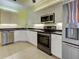 Kitchen with white cabinets, black counters, stainless appliances, and tile floor at 912 Barclay Ct, Venice, FL 34293