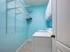 Laundry room with blue walls, tile floors, wire shelving and a front-load washing machine and dryer at 912 Barclay Ct, Venice, FL 34293
