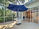 Enjoy the outdoors on this screened lanai featuring an umbrella, table, and access to the interior with a fireplace at 912 Barclay Ct, Venice, FL 34293