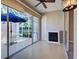 Covered patio with white floor, fireplace, sliding glass doors, blue umbrella and view of pool at 912 Barclay Ct, Venice, FL 34293