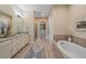 Bright bathroom featuring double vanity, soaking tub, walk-in shower, and large walk-in closet at 9220 43Rd W Ter, Bradenton, FL 34209