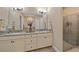 Bathroom with double vanity with granite countertop and glass-enclosed shower at 9220 43Rd W Ter, Bradenton, FL 34209