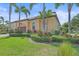 Charming single-story home featuring a tile roof, arched windows, well maintained lawn, and tropical landscaping at 9220 43Rd W Ter, Bradenton, FL 34209