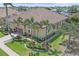 Stately home with a terracotta roof, lush landscaping, paver driveway, and mature palm trees at 9220 43Rd W Ter, Bradenton, FL 34209