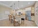 Kitchen with island, breakfast bar, white cabinetry, stainless appliances, and modern lighting fixtures at 9220 43Rd W Ter, Bradenton, FL 34209