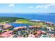 An aerial view shows resort condos with red roofs surrounded by canals, a large pond, and the ocean at 97 Vivante Blvd # 306, Punta Gorda, FL 33950