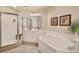 Bright bathroom featuring a stand up shower, large bathtub, and white tiled flooring at 97 Vivante Blvd # 306, Punta Gorda, FL 33950