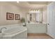 Bright bathroom with a large bathtub, white cabinets and modern fixtures at 97 Vivante Blvd # 306, Punta Gorda, FL 33950