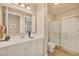 Bright bathroom featuring a white vanity, framed mirror, and glass-enclosed shower at 97 Vivante Blvd # 306, Punta Gorda, FL 33950