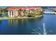 Exterior shot of waterfront condos with lush landscaping, a bridge, and a tranquil water feature at 97 Vivante Blvd # 306, Punta Gorda, FL 33950