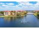Exterior of waterfront condos with lush landscaping, a bridge, and a tranquil water feature at 97 Vivante Blvd # 306, Punta Gorda, FL 33950