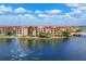 Exterior of waterfront condos with lush landscaping, a bridge, and a tranquil water feature at 97 Vivante Blvd # 306, Punta Gorda, FL 33950