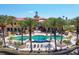 Inviting community pool area with palm trees, lounge chairs, and a domed tower in the background at 97 Vivante Blvd # 306, Punta Gorda, FL 33950