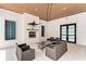 Outdoor seating area with cozy fireplace, ceiling fan and a decorative marlin, perfect for relaxation at 9823 Haze Dr, Venice, FL 34292