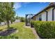 Well-maintained backyard features lush green grass, mature trees, and a screened-in patio at 9823 Haze Dr, Venice, FL 34292