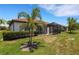 The backyard includes a screened-in patio, lush grass, and tropical palm trees at 9823 Haze Dr, Venice, FL 34292