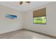 Comfortable bedroom showcasing tile flooring, bright window, and a ceiling fan at 9823 Haze Dr, Venice, FL 34292