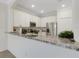 Modern kitchen with stainless steel appliances and granite countertops with a bar-style dining area at 9823 Haze Dr, Venice, FL 34292