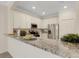 Modern kitchen with stainless steel appliances and a granite countertop bar area, perfect for entertaining at 9823 Haze Dr, Venice, FL 34292
