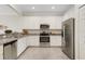 Modern kitchen features stainless steel appliances, white cabinets, and stylish granite countertops at 9823 Haze Dr, Venice, FL 34292