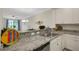 Bright kitchen area with stainless appliances, granite counters, open to dining area at 9823 Haze Dr, Venice, FL 34292