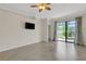 Bright living area with tile flooring, ceiling fan, sliding doors opening to the backyard at 9823 Haze Dr, Venice, FL 34292
