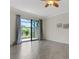 Light filled living area showcasing tile flooring, sliding doors, and elegant ceiling fan at 9823 Haze Dr, Venice, FL 34292