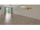 Open living room with tile flooring, a ceiling fan, and sliding glass doors to the outdoor area at 9823 Haze Dr, Venice, FL 34292