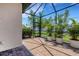 Screened-in patio with brick flooring and tropical plants, perfect for outdoor relaxation at 9823 Haze Dr, Venice, FL 34292