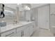 Bathroom with double sinks, white cabinets, granite countertop and tile accents at 10121 Beachwalk Dr, Englewood, FL 34223
