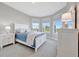 Bedroom with neutral walls, carpet and several windows, filling the room with natural light at 10121 Beachwalk Dr, Englewood, FL 34223